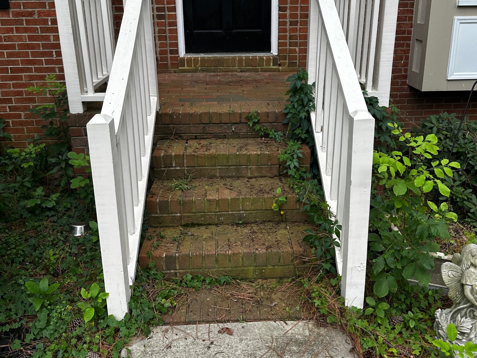 Mossy brick porch steps before cleaning